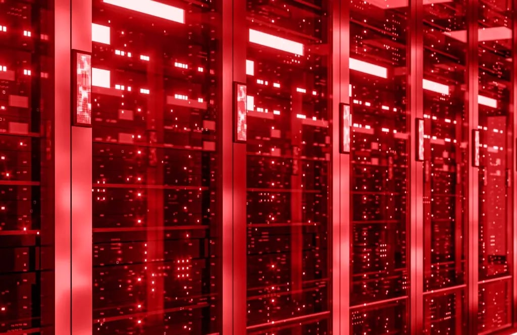 Row of server racks with illuminated red LED lights in a data center. Representation of backbone infrastructure, network technology and data transmission.